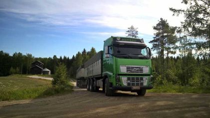 vihreä rekka-auto perävaunuyhdistelmällä metsätiellä